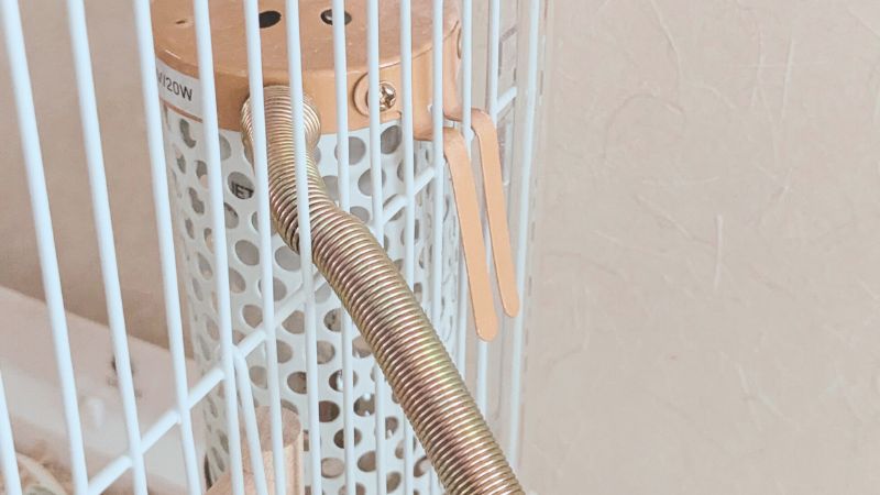 ケージの網に取り付けたマルカン保温電球カバー付き20w