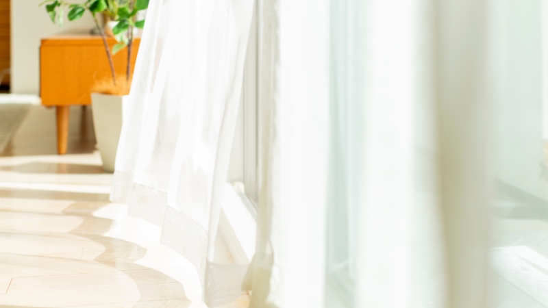 風で揺れている窓のカーテン