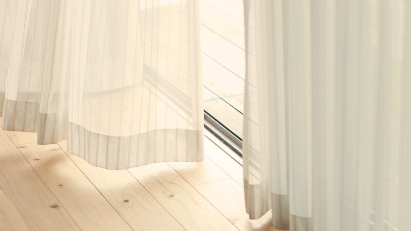 風に揺れている窓辺のカーテン